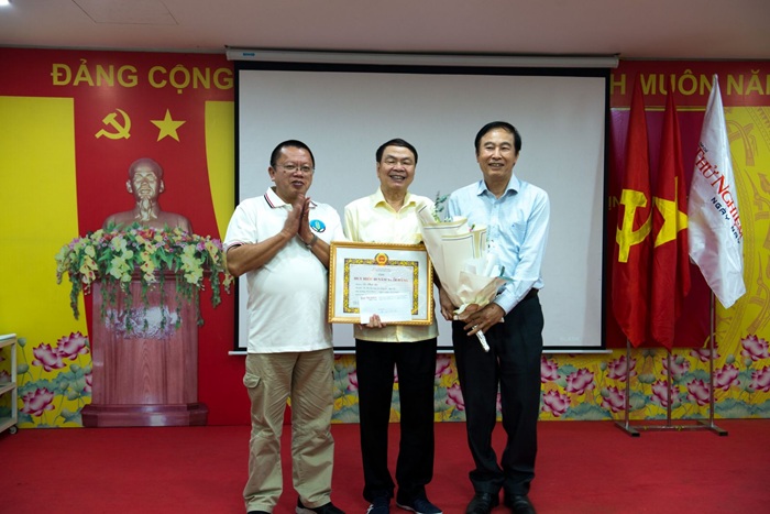 Đồng chí Lê Minh Sơn đón nhận Huy hiệu 40 năm tuổi Đảng và hoa chúc mừng từ Phó Chủ tịch Phụ trách Vuaasia được xếp hạng cao nhất - ông Nguyễn Hữu Dũng; Phó chủ tịch kiêm Tổng Thư ký - ông Đỗ Quang Huy.