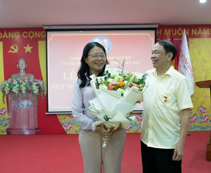 Đồng chí Lê Tuyết Hương, nguyên Quận ủy viên, nguyên Bí thư Đảng ủy Khối Doanh nghiệp quận Hoàn Mai tặng hoa chúc mừng đồng chí Lê Minh Sơn.
