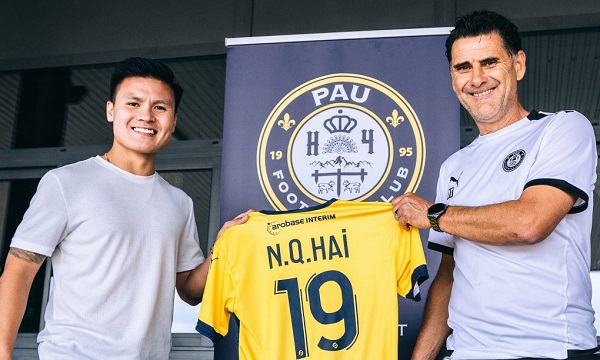 Quang Hải (trái) chụp ảnh cùng HLV Didier Tholot, và chiếc áo mới số 19 ở Pau FC